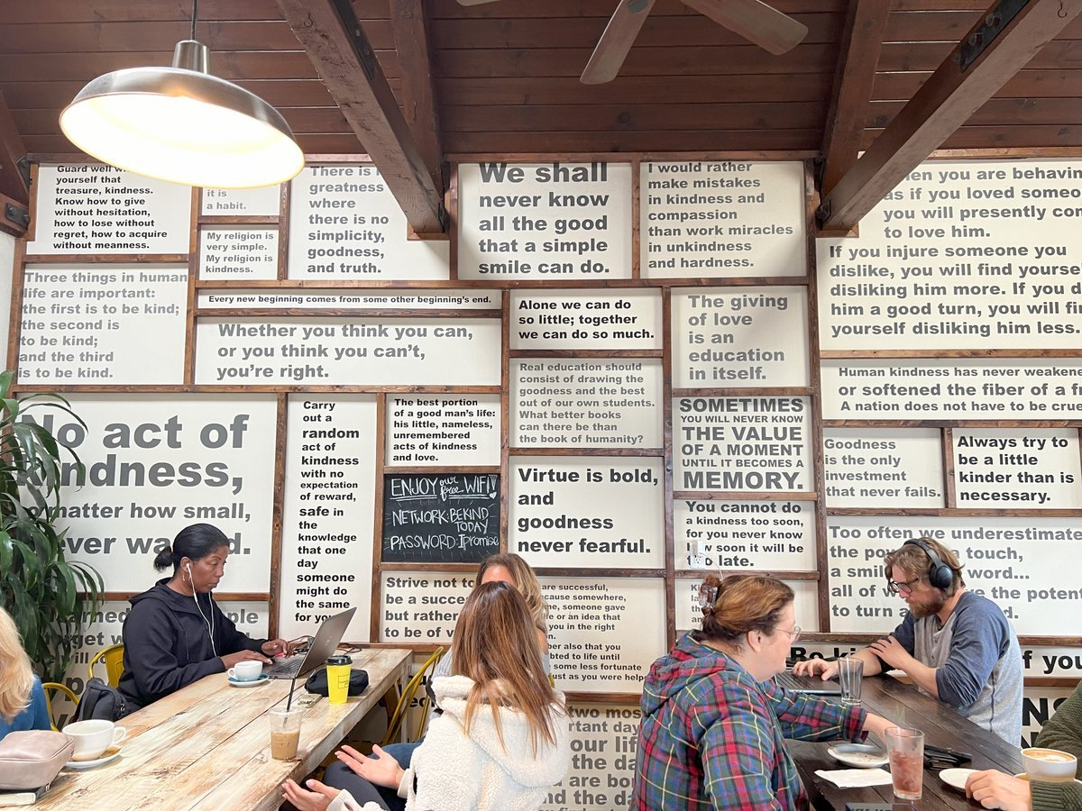 Interior of Bondadoso Coffee with people dining and with motivational slogans visible